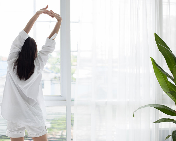 Woman doing stretching in front of a window
